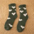 Primo piano dei dettagli di calze invernali in pile soffice verde con cuori bianchi. - Taglia 35-40 / Verde Scuro