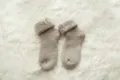 Close up view of cozy thick winter thermal wool socks in neutral beige on soft texture rug. - One Size / Khaki