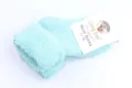 Detailopname van lichtgroene dikke kinderwollen sokken met omslagmanchet en merklabel. - 0-2 jaar / Meergroen