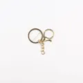Dettaglio accessorio portachiavi in metallo dorato, con moschettone e anello brisè. - Portachiavi N. 2 / Confezione da 10 / Oro