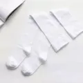 Nahaufnahme von weißen Overknee-Socken flach ausgelegt auf strukturierter Oberfläche. - Einheitsgröße / Weiß