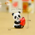 Detailed close-up view of a cute resin panda miniature holding a red heart ornament for desktop. - Heart Panda