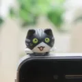 Close-up detail van de schattige cartoon kat stofplug voor 3.5mm koptelefoonaansluiting, miniatuur. - Zwarte Kat met Omhoogstaand Achterwerk