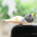 Schattige kat telefoon stofplug figuur, creatieve 3.5 mm koptelefoon aansluiting accessoire. - Driekleurige liggende kat met lange staart