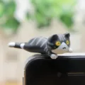 Detail van schattig grijs gestreept kattenbeeldje, leuke stofplug en minidecoratie. - Zwarte Liggende Kat met Lange Staart