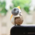 Close-up opname van een schattig driekleurig katten beeldje met een handig stofdop detail. - Kat spelend met wolbal