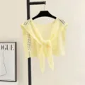 Close-up detail of hollow-out knit shawl, lightweight hollow pattern, tie-front design. - Yellow