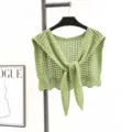 Detail view of the green hollow-out knitted women shawl, featuring a front tie and lace hem. - Green