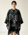 Black and white plaid poncho detail, showing the soft tassel hem and warm winter fabric. - Four-Line Plaid Shawl - Black