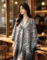 Vista dettagliata della mantella scialle effetto cashmere con motivo chevron e frange. - Scialle con Nappe Chevron / Nappa Grigia