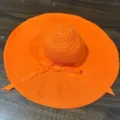 Vue rapprochée du chapeau de soleil orange vif avec un joli ruban nœud élégant. - Orange