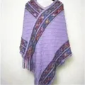 Detailed view of a cozy purple knit poncho with vibrant patterned borders and soft fringe. - Diamond Plaid Cloak / Purple