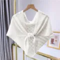 Hollow-out knit shawl detail showing the fine mesh texture and front tie knot design. - White