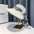 Nahaufnahme Detail des breitkrempigen Strohhutes mit Blumenband für den Sommergebrauch. - Haarband mit Blumenmuster - Weiß