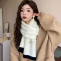 Gros-plan sur une écharpe en tricot blanc doux avec des extrémités noires et cosy. - Tricot de base contrasté - 10 blanc de lait