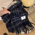 Primer plano detallado de la bufanda de invierno a cuadros azul oscuro con flecos. - Azul marino