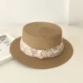 Detailansicht des sommerlichen flachen Damen-Strohhuts mit floralem Chiffonband. - Khaki