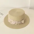 Detailansicht eines flachen Strohhutes für Damen mit elegantem Blumen-Netzband. - Beige