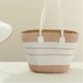 Detailed view of the straw woven handbag with white and brown stripes and elegant leather handles. - Single Bag / Pink