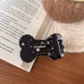 Detailansicht der schwarzen sternenbedruckten knochenförmigen Haarklammer auf Buch. - Schwarz mit Weißen Sternen