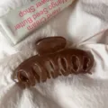 Detail shot of a dark brown large hollow hair claw clip, minimalist design for daily hairstyles. - Round Head Dragon Bone / Large Style / Transparent Brown