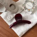 Vue détaillée de la pince à cheveux rouge foncé sur tissu blanc avec tasse et boîte. - Papillon Petite (cszj22-0078) / Cerise
