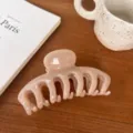 Close-up detail of a minimalist nude pink hair claw clip placed on a stylish wooden desk. - Round Head Dragon Bone / Large Style / Light Nude Pink