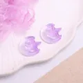 Detailed shot of purple translucent star and moon resin DIY hair clips and craft patches. - Moon & Star