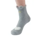 Gros plan de chaussettes douillettes en polaire corail grise avec oreilles de chat. - Taille unique / Gris clair
