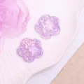 Close-up view of purple glitter flower resin charms for DIY hair accessories and crafts. - Plum Blossom