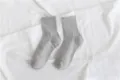 Close-up detail of soft grey crew socks featuring ribbed cuffs, placed on white fabric. - Size 35-40 / Light Gray