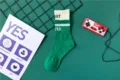 Detailaufnahme von gruen-weissen Baumwoll-Mittel-Socken mit gestrickten Buchstaben, casual. - EU 40-44 / Grün