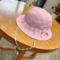 Pink baby bucket hat detail showing floral lace trim, cute bow, and adjustable chin strap. - Taro Purple Lace Bows