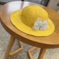 Yellow toddler bucket hat with grey lace bow detail, closeup shot on wooden table. - 48-54CM / Yellow