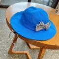 Close-up detail of blue kids bucket hat with black white houndstooth bow and adjustable strap. - Royal Blue Houndstooth Bows