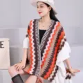 Vue détaillée de la cape en tricot ethnique à franges pour femmes avec manches à volants. - Style ethnique en tricot [Orange]
