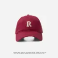 Burgundy baseball cap with white embroidered R letter patch, classic curved brim design. - Adjustable (55-59cm) / R Badge / Burgundy