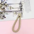 Beige braided leather keychain lanyard with metal ring and lobster clasp close-up view. - Wrapped Leather Cord / Brown
