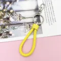 Detailed view of yellow braided leather keychain strap with metal hardware, close-up presentation. - Wrapped Leather Cord / Yellow