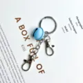 Cute light blue bell keychain with double lobster clasps for stylish bags and keys. - Blue