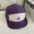 Detailansicht der lila-weißen 5-Panel-Mütze mit dreieckiger SJ-Stickerei auf der Vorderseite. - M (56-58cm) / Lila