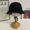 Detailed view of the black crochet bucket hat, featuring a hollow knit design and thin chin straps. - M (56-58cm) / Black