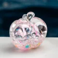 Gros plan détaillé d'un ornement transparent en forme de pomme bouteille de sable - Rose