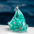 Porte-clés sable mouvant voilier en acrylique transparent avec paillettes et perles vertes. - Vert