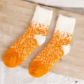 Closeup of cozy orange and white gradient fuzzy home socks, thick plush material for winter warmth. - Yellow