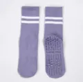 Non-slip yoga socks detail view featuring purple fabric, white stripes, and grip dots. - One Size / Purple