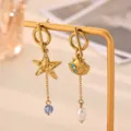 Detailed closeup view of golden stainless steel asymmetrical starfish and seashell earrings. - Asymmetric Starfish Shell Style (E6827G)