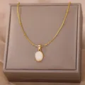 Exquisite detail close-up of the elegant oval white stone pendant necklace on a jewelry box. - Gold Pink Cat's Eye Stone Style