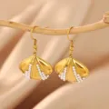 Close-up of gold shell-shaped earrings with delicate white pearl inlay, elegant detail view. - Hook Shell Pearl Style (E7372)