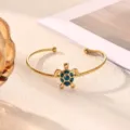 Gold-tone stainless steel open cuff bracelet featuring a charming blue glitter turtle charm detail. - Blue Glitter Turtle Style (B2307G-1)